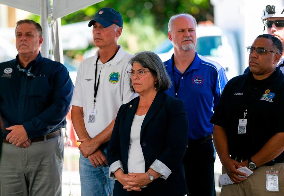 Miami-Dade County Mayor Daniella Levine Cava, center, listens as Florida Gov. Ron DeSantis speaks during a press conference near the Champlain Towers South collapse site in Surfside, Florida, on Saturday, July 3, 2021.