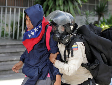 A riot police officer takes an opposition supporter during clashes at a rally against Venezuela's President Nicolas Maduro in Caracas, Venezuela May 20, 2017. REUTERS/Christian Veron