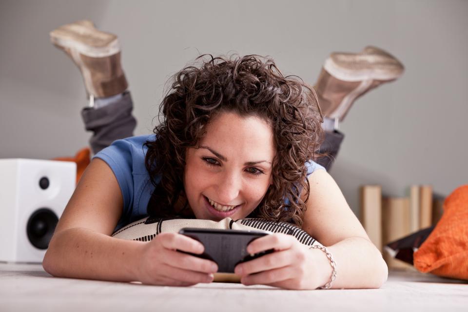 Woman laying on the floor using her cell phone.