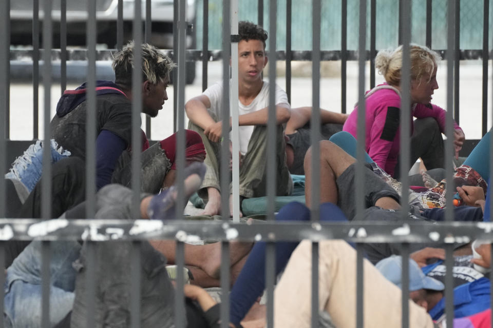 Recently arrived migrants wait in a garage area of the U.S. Customs and Border Protection - Marathon Border Patrol Station, Wednesday, Jan. 4, 2023, in Marathon, Fla. More than 500 Cuban immigrants have come ashore in the Florida Keys since the weekend, the latest in a large and increasing number who are fleeing the communist island. (AP Photo/Wilfredo Lee)