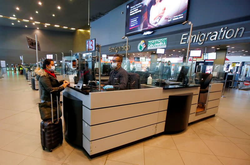 Passengers and staff wear protective face masks to avoid contracting coronavirus, at El Dorado international airpot in Bogota