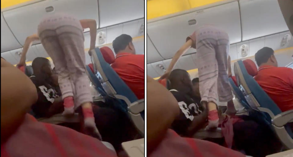 woman wearing pink pants climbs over plane passengers