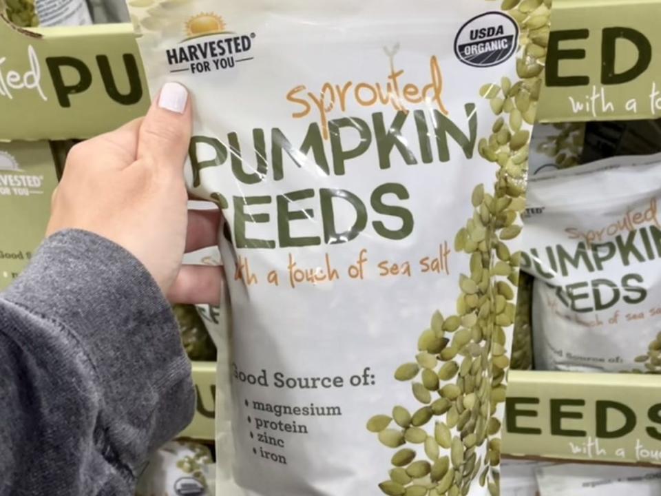 hand holding a bag of sprouted pumpkin seeds at costco