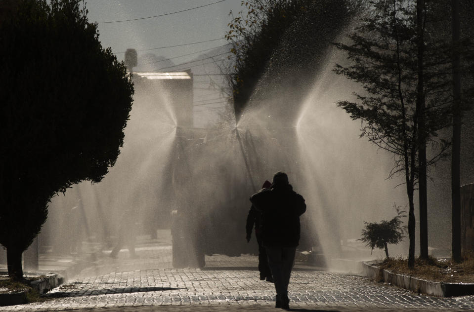 A tanker truck sprays disinfectant in the Villa Jaime Paz Zamora neighborhood of El Alto, Bolivia, Saturday, July 4, 2020, as measure to curb the spread of the new coronavirus. (AP Photo/Juan Karita)