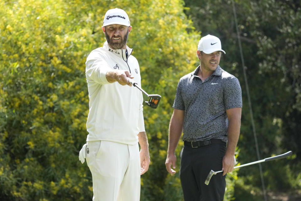 Dustin Johnson, left, and Brooks Koepka measure their putts on the third green during a practice round of the U.S. Open golf tournament at Los Angeles Country Club, Monday, June 12, 2023, in Los Angeles. (AP Photo/Marcio Jose Sanchez)