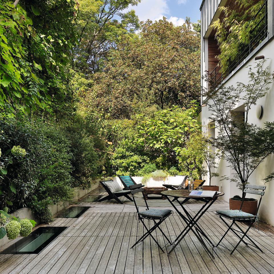 Garden with shaded decking area and garden furniture on it.