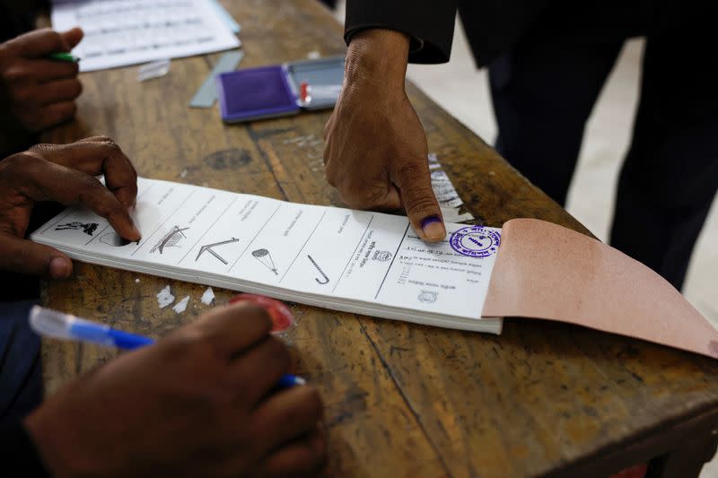 A voter puts their fingerprint on the ballot paper before casting a vote during the 12th general election in Dhaka