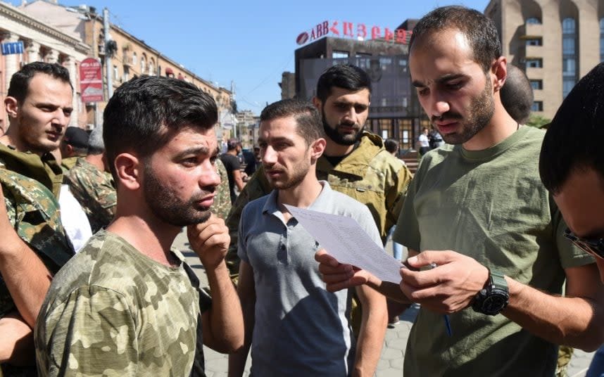 Men attend a meeting to recruit military volunteers after Armenian authorities declared martial law and mobilised its male population following clashes with Azerbaijan over the breakaway Nagorno-Karabakh region - Melik Baghdasaryan