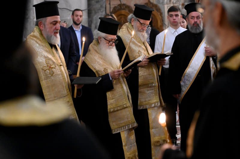 Greek Orthodox priests join the Patriarch of Jerusalem Theophilos III, not seen, in prayers during a memorial service for the souls of the Gaza war victims and the bombing in Gaza of the Church of Saint Porphyrios, in the Church of the Holy Sepulchre in the Old City of Jerusalem, on Sunday. Photo by Debbie Hill/ UPI