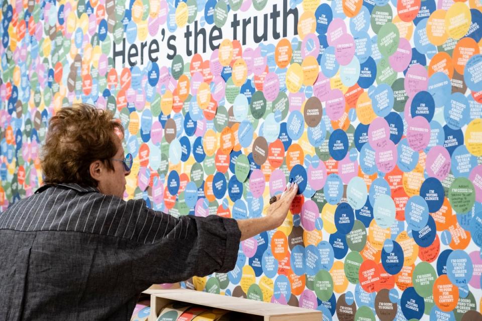 A visitor adds their sticker to the ‘truth wall’ at the Climate Museum (The Climate Museum/Sari Goodfriend)