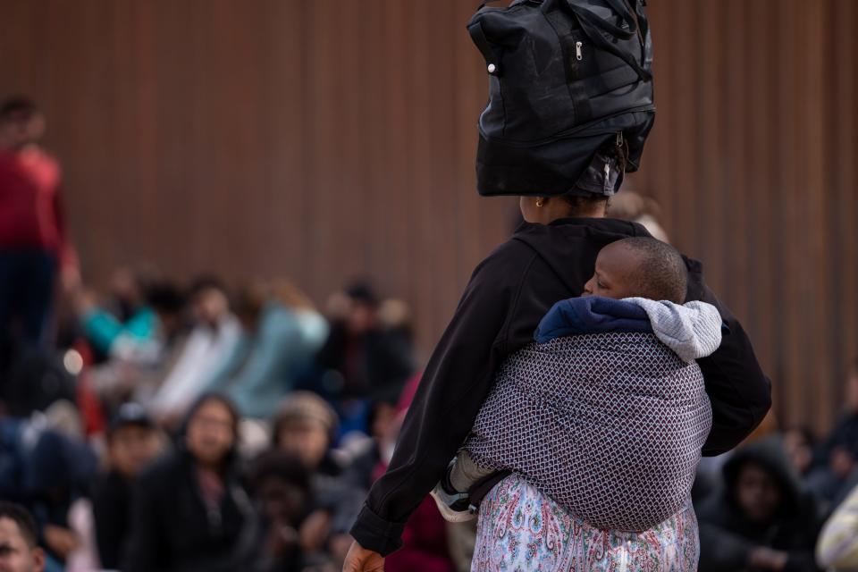 Migrants and asylum seekers wait to be picked up and processed by U.S. Border Patrol agents in Organ Pipe Cactus National Monument along the U.S.-Mexico border about a mile west of Lukeville, Ariz., on Dec. 4, 2023. The Lukeville Port of Entry was closed indefinitely by officials Dec. 4.