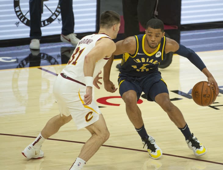 Indiana Pacers' Cassius Stanley (2) drives past Cleveland Cavaliers' Matt Mooney (31) during the second half of an NBA preseason basketball game Monday, Dec. 14, 2020 in Cleveland. (AP Photo/Phil Long)