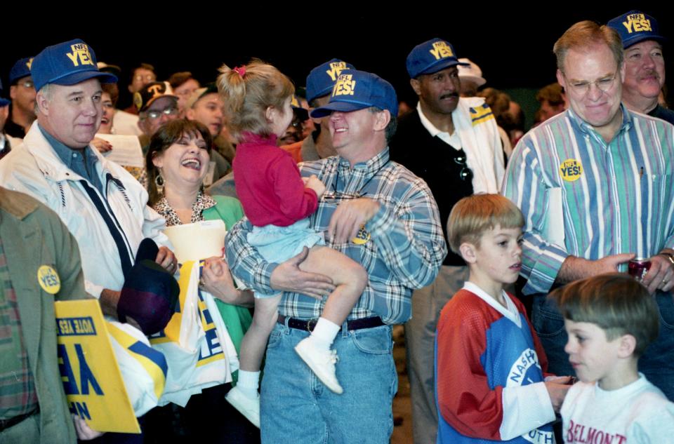 Bobby Joslin, center, laughs as he 3-year-old daughter Kayla pulls his NFL YES! Hat over his eyes at the campaign kickoff rally for Yes for Nashville at MetroCenter March 23, 1996. They want a "yes" vote on the $80 million stadium referendum for the Houston Oilers that set for May 7.