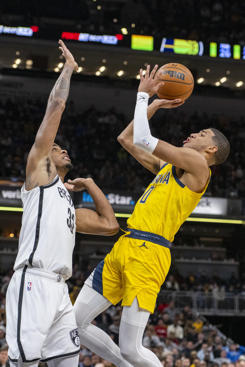 Indiana Pacers guard Tyrese Haliburton (0) shoots over the defense of Brooklyn Nets forward Nic Claxton (33) during the second half of an NBA basketball game in Indianapolis, Friday, Nov. 25, 2022. (AP Photo/Doug McSchooler)