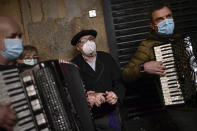 People wear face masks as they sing a song in honor of Saint Saturnine, on his festivity day, in Pamplona, northern Spain, Monday, Nov. 29, 2021. (AP Photo/Alvaro Barrientos)