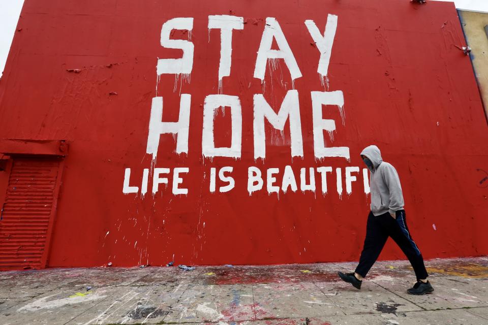 Ein Mann geht an einem Graffiti «Stay Home Life is Beautiful» in der Innenstadt von Los Angeles vorbei. Foto: Xinhua / dpa