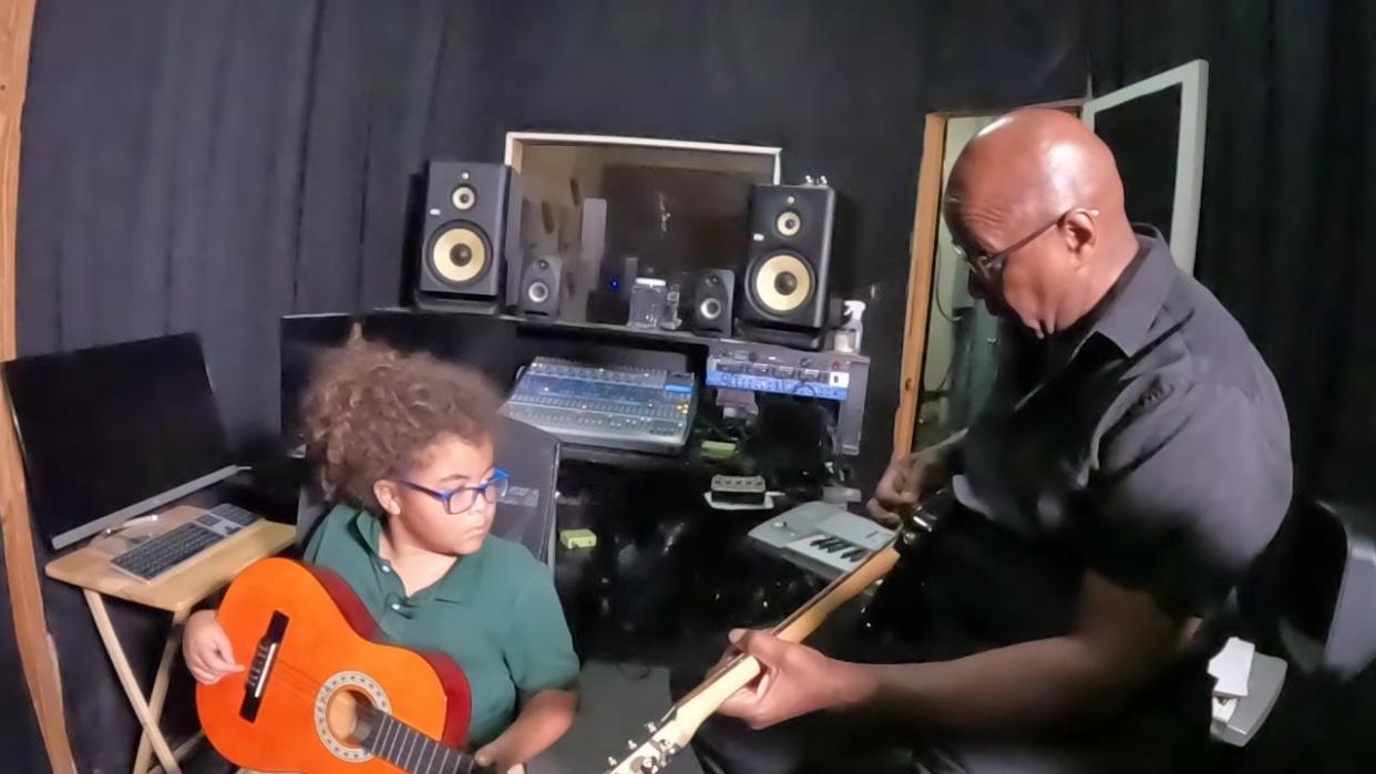 <div>Hazley teaches 8-year-old Diamante Agurre how to play guitar.</div>