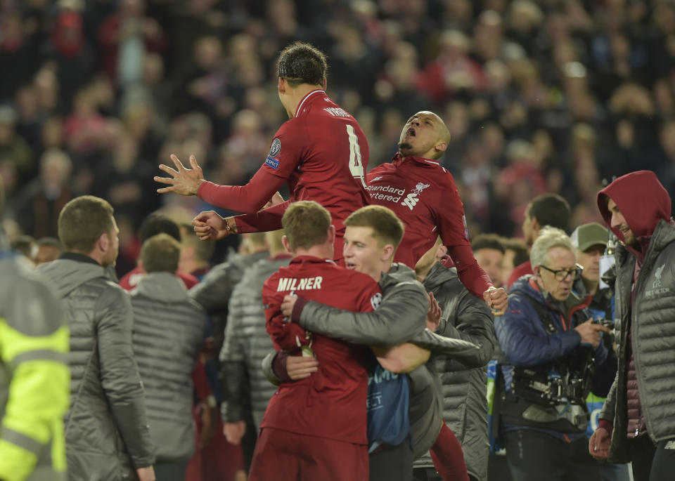 Virgil van Dijk and Fabinho are lifted up by fellow players