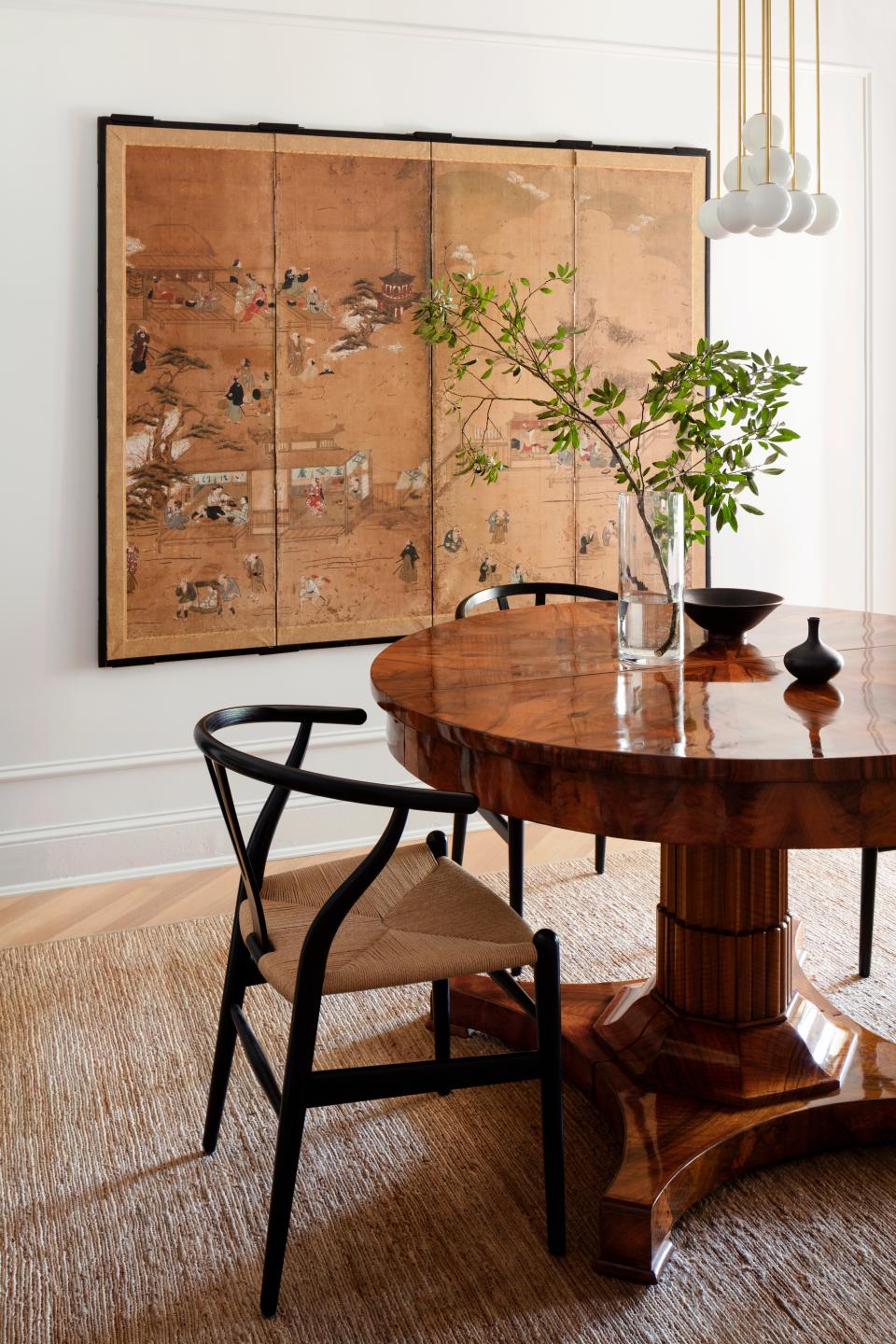 “The dining room almost feels as though it’s floating in the apartment—it really stands on its own,” Nicholas says. An early-19th-century German antique table is complemented by Hans J. Wegner chairs. A Japanese screen and a Danish shelf, both vintage, are on the ends of the room, with a Michael Anastassiades chandelier overhead.