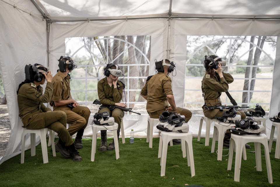 Israeli soldiers watch a virtual tour of the destruction of the aftermath of the Oct. 7 Hamas attack on Israel near the site of the Tribe of Nova music festival, where at least 364 people were killed and abducted near Kibbutz Re'im, southern Israel, Thursday, May 30, 2024. A new kind of tourism has emerged in Israel in the months since Hamas’ Oct. 7 attack. For celebrities, politicians, influencers and others, no trip is complete without a somber visit to the devastated south that absorbed the brunt of the assault near the border with Gaza. (AP Photo/Oded Balilty)