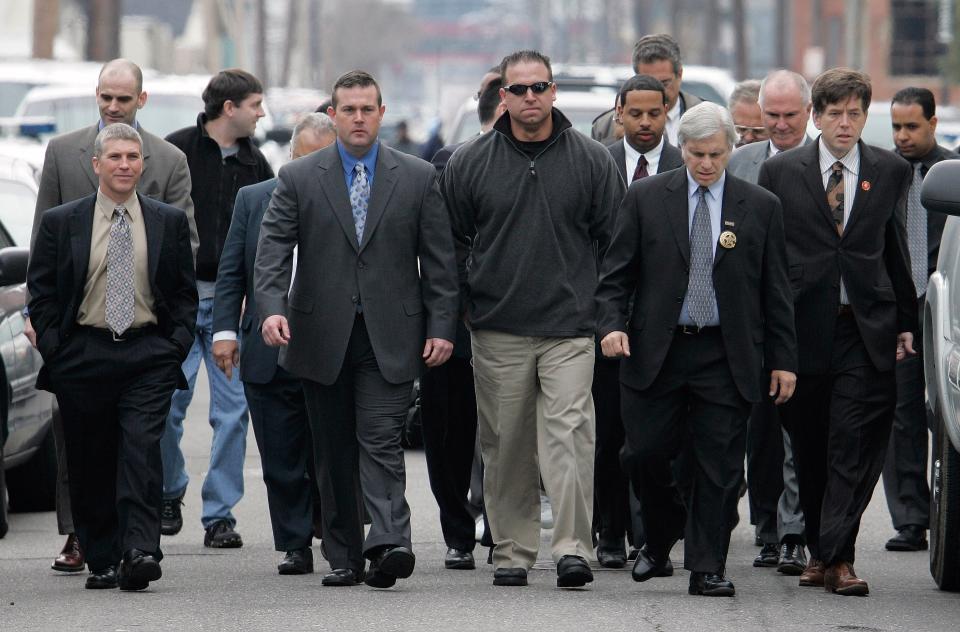 New Orleans police officers with their attorneys and supporters arrive to turn themselves in at the city jail in New Orleans in 2007. Five officers were ultimately convicted for their role in the Danziger Bridge shootings.