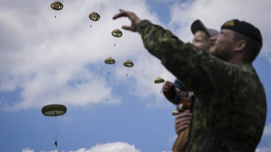 <em>A boy and his father attend a multinational parachute drop as some 400 British, Belgian, Canadian and US paratroopers jump to commemorate the contribution of airborne forces on D-Day. as part of the 80th anniversary of D-Day, in Sannerville, Normandy, France, Wednesday, June 5, 2024. Veterans and world dignitaries gather in Normandy to commemorate the 80th anniversary of the landings. (AP Photo/Laurent Cipriani)</em>