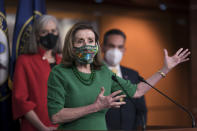 Speaker of the House Nancy Pelosi, D-Calif., meets with reporters before the House votes to pass a $1.9 trillion pandemic relief package, during a news conference at the Capitol in Washington, Friday, Feb. 26, 2021. Pelosi is flanked by Rep. Katherine Clark, D-Mass., left, and Rep. Pete Aguilar, D-Calif. (AP Photo/J. Scott Applewhite)