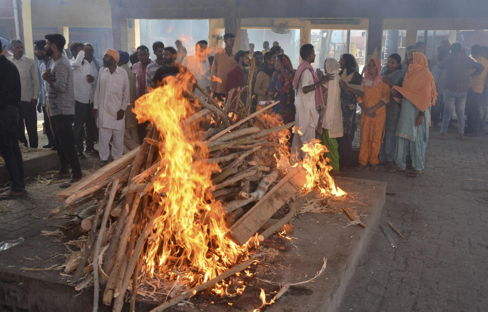 The funeral pyre of a victim of Friday's train accident goes up in flames in Amritsar, India, Saturday, Oct. 20, 2018. A speeding train ran over a crowd watching fireworks during a religious festival in northern India on Friday evening, killing more than 50 people and injuring dozens more, police said. (AP Photo/Prabhjot Gill)