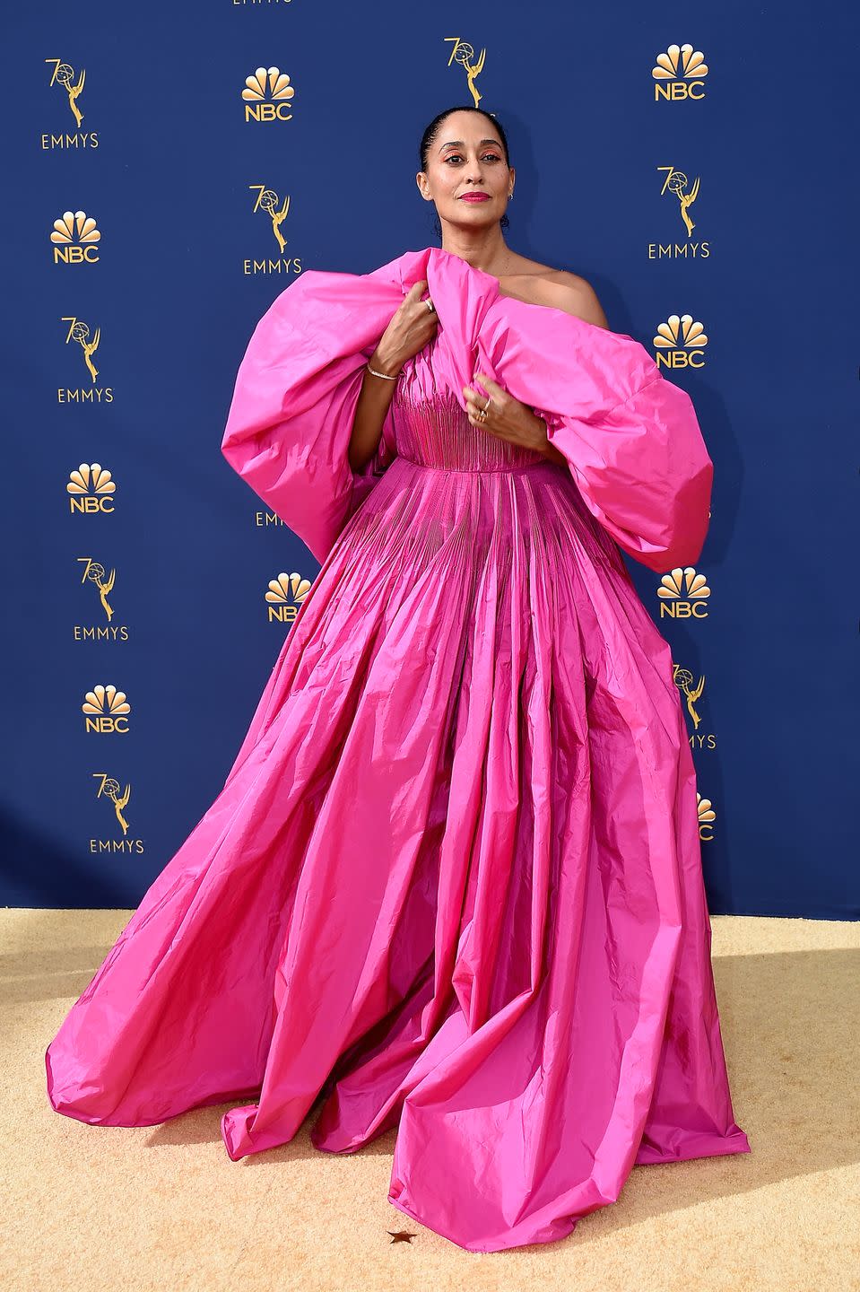 <p>In a voluminous hot pink gown with pleating at the bodice. </p>