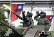 FILE - In this Oct. 10, 2021, file photo, Taiwanese soldiers salute during National Day celebrations in front of the Presidential Building in Taipei, Taiwan. After sending a record number of military aircraft to harass Taiwan over China’s National Day holiday weekend, Beijing has toned down the sabre rattling but tensions remain high, with the rhetoric and reasoning behind the exercises unchanged. (AP Photo/Chiang Ying-ying, File)