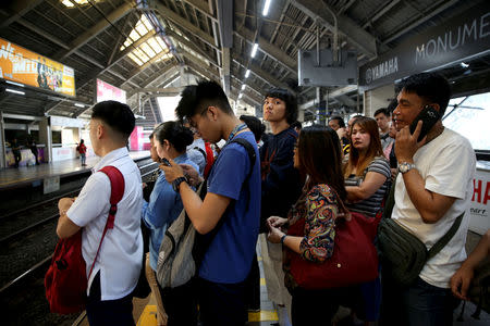 Oliver Emocling, 23, who works for a magazine, waits for the train with other passengers at a train station in Caloocan City, Metro Manila, Philippines, October 15, 2018. Queues are often an issue in Emocling's commute, which sometimes take as long as 30 minutes to an hour. When the queue is unreasonably long, he takes a roundtrip to another station where the crowd is not as deep. "Instead of waiting, I'd rather spend more money because if I'm late to work, I lose more." Emocling said he once received only half of his salary because of the number of times he arrived late due to long queues. REUTERS/Eloisa Lopez