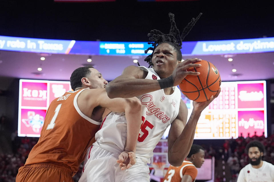 Houston's Joseph Tugler (25) is fouled by Texas' Dylan Disu (1) during the second half of an NCAA college basketball game Saturday, Feb. 17, 2024, in Houston. Houston won 82-61. (AP Photo/David J. Phillip)
