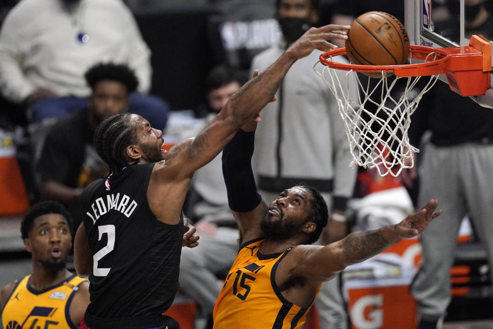 Los Angeles Clippers forward Kawhi Leonard, center, dunks over Utah Jazz center Derrick Favors, right, as guard Donovan Mitchell watches during the first half in Game 4 of a second-round NBA basketball playoff series Monday, June 14, 2021, in Los Angeles. (AP Photo/Mark J. Terrill)