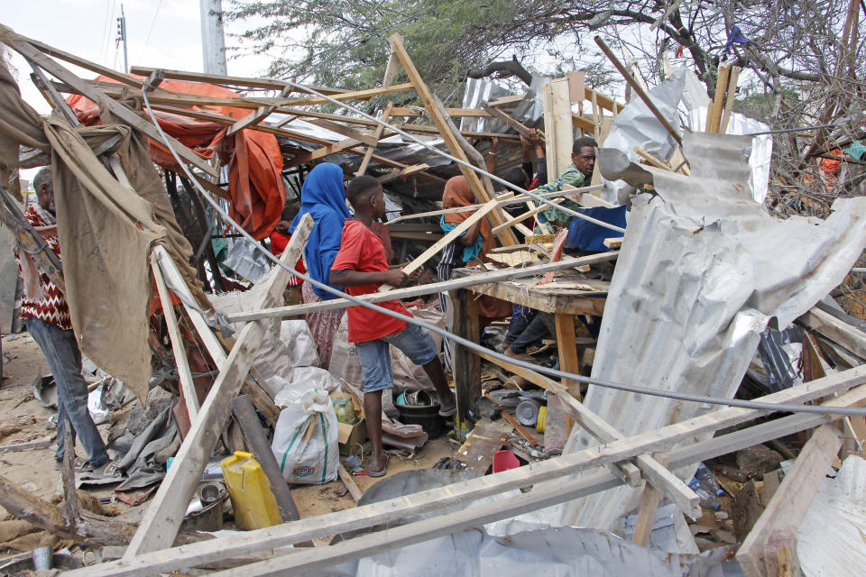 Somalis salvage goods after shops were destroyed in a car bomb in Mogadishu, Somalia, Saturday, Dec. 28, 2019. A truck bomb exploded at a busy security checkpoint in Somalia's capital Saturday morning, authorities said. It was one of the deadliest attacks in Mogadishu in recent memory. (AP Photo/Farah Abdi Warsame)