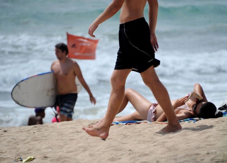 Foreign tourists relax on Kuta beach in Denpasar, Bali on January 23, 2013. Drug syndicates are using Westerners to smuggle drugs into Bali, Indonesian authorities said as a British grandmother became the latest to face the firing squad for trafficking