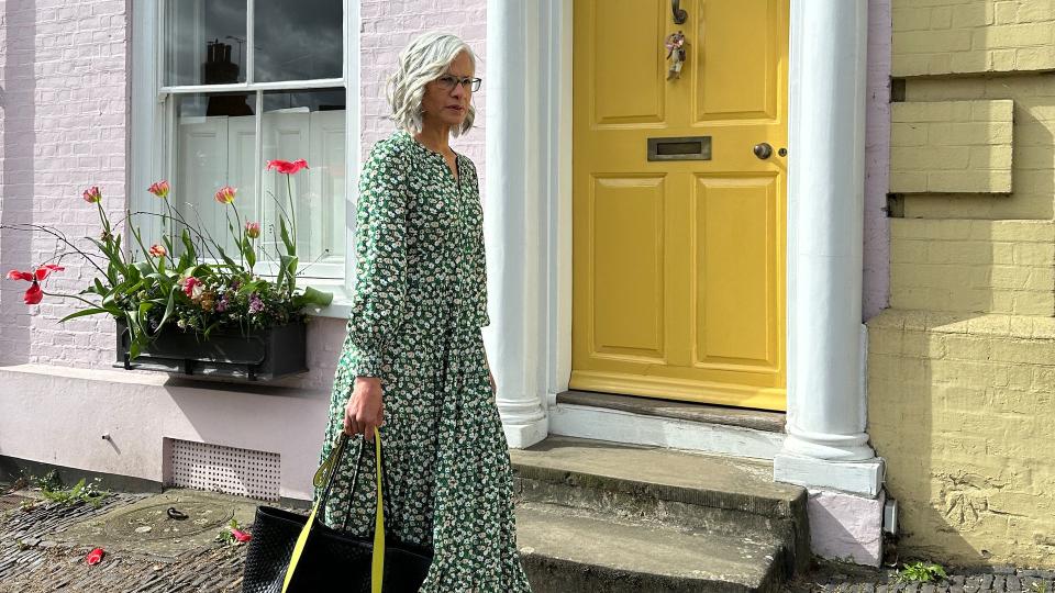 Woman walking outside with a yellow bag