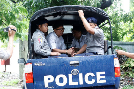 Detained Reuters journalists Wa Lone and Kyaw Soe Oo leave in a police vehicle after a court hearing in Yangon, Myanmar May 29, 2018. REUTERS/Ann Wang