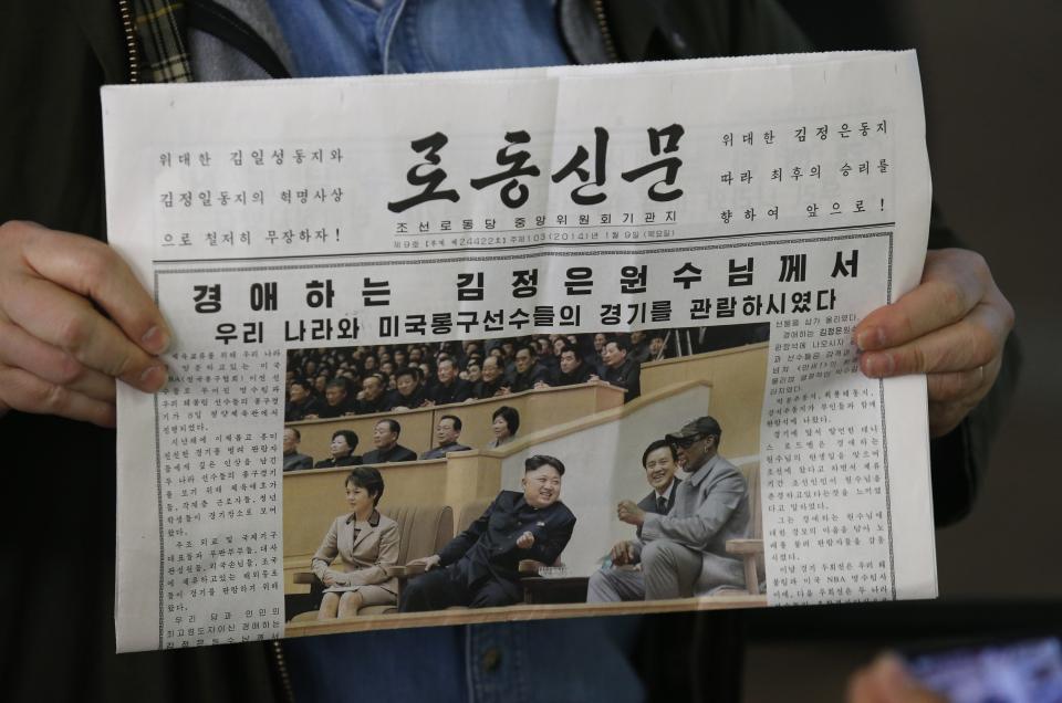 U.S. tourist Sokmensuer shows copy of North Korea's Rodong Sinmun newspaper featuring North Korean leader Kim and Rodman, in Beijing airport