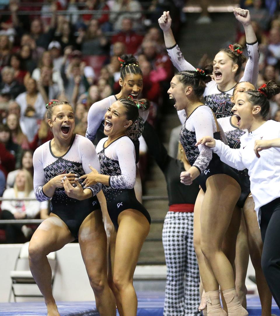 Feb 24, 2023; Tuscaloosa, AL, USA;  Alabama gymnast Lilly Hudson, left, reacts with teammates after scoring her first 10.0 on the beam at Coleman Coliseum during the meet against LSU.