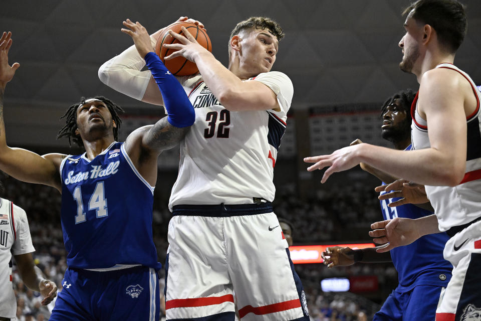 UConn center Donovan Clingan (32) grabs a rebound against Seton Hall guard Dre Davis (14) in the first half of an NCAA college basketball game, Sunday, March 3, 2024, in Storrs, Conn. (AP Photo/Jessica Hill)