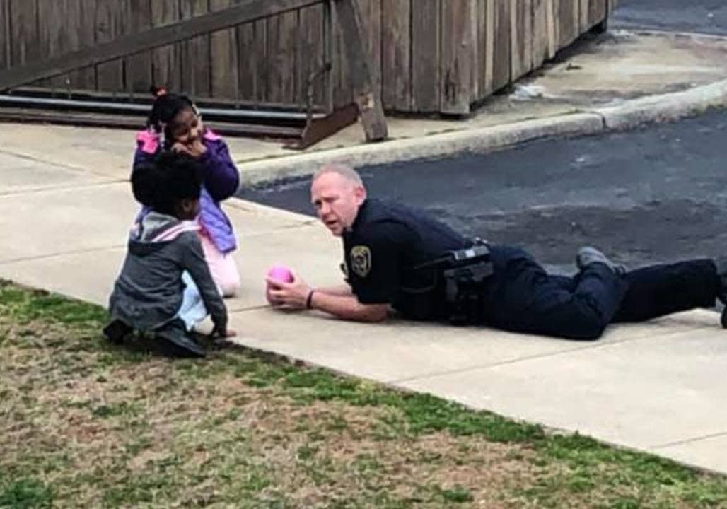 Brandon Fleming liegt auf dem Boden und spielt mit Puppen. Er möchte den beiden Mädchen die Angst vor Polizisten nehmen. (Foto: privat / Facebook / Iesha Roper Boswell)