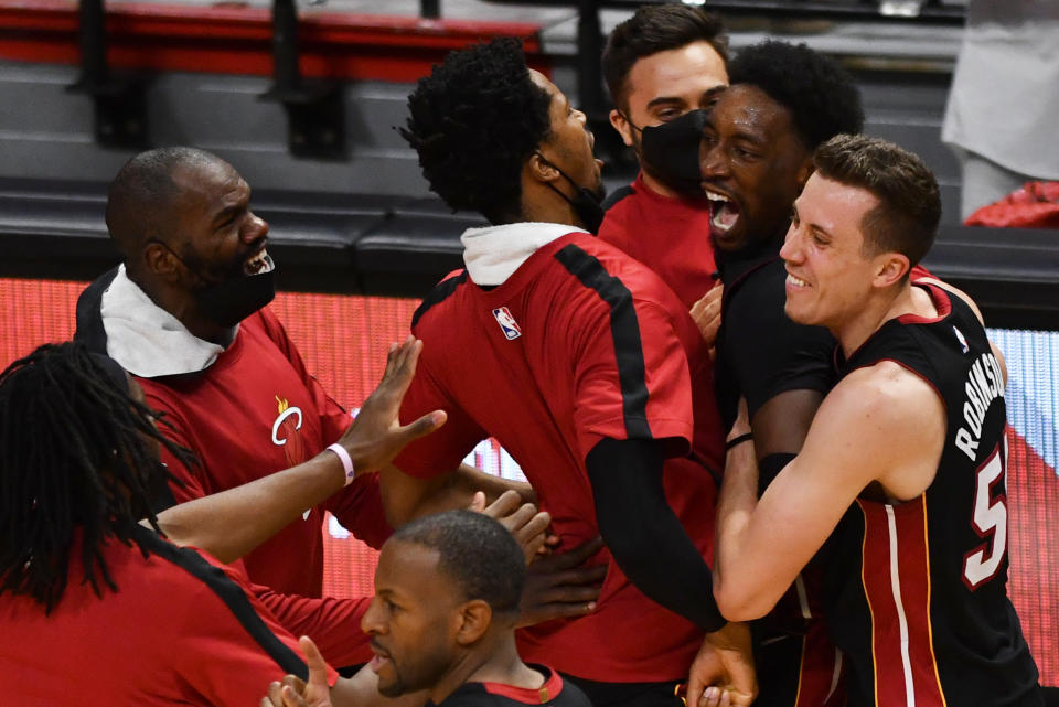 Apr 18, 2021; Miami, Florida, USA; Miami Heat center Bam Adebayo (top right) celebrates a winning shot over the Brooklyn Nets with teammates at American Airlines Arena. Mandatory Credit: Jim Rassol-USA TODAY Sports