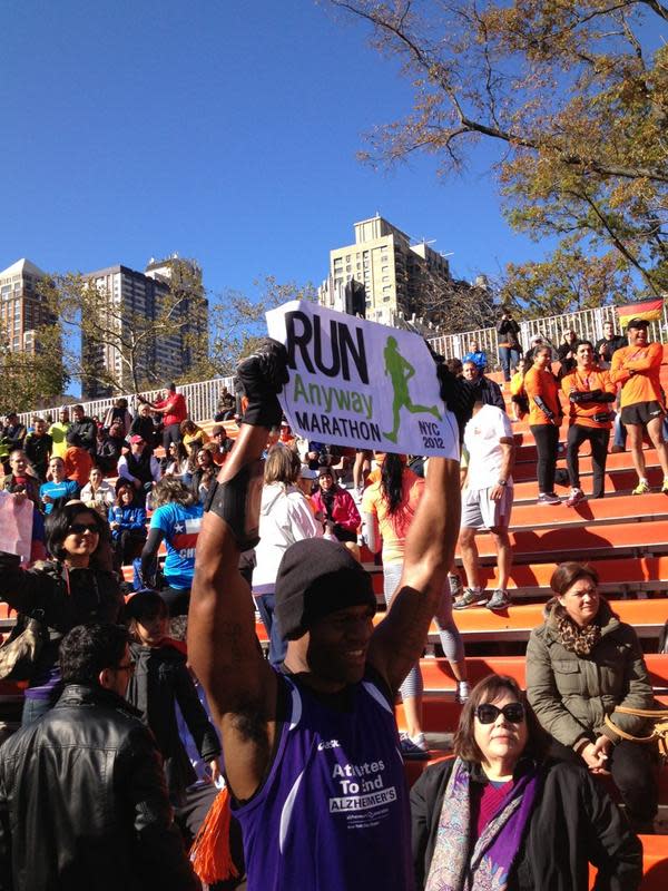 People in the still set-up finish line stands cheering thousands of unofficial #NYCMarathon runners.