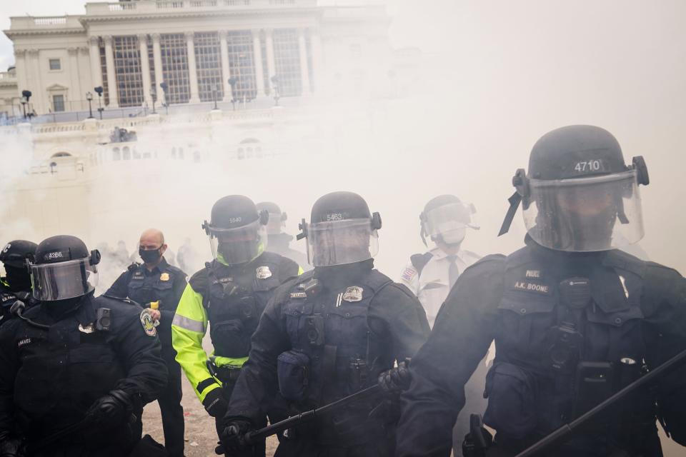 Supporters loyal to President Donald Trump clash with authorities before successfully breaching the Capitol building during a riot on the grounds, on Jan. 6, 2021.