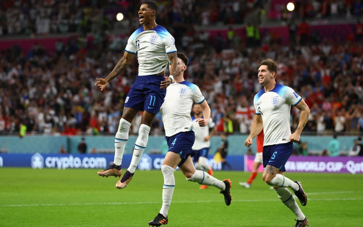 England's Marcus Rashford celebrates scoring his first goal against Wales with Declan Rice and John Stones at the FIFA World Cup Qatar 2022 - November 29, 2022 - HANNAH MCKAY/REUTERS