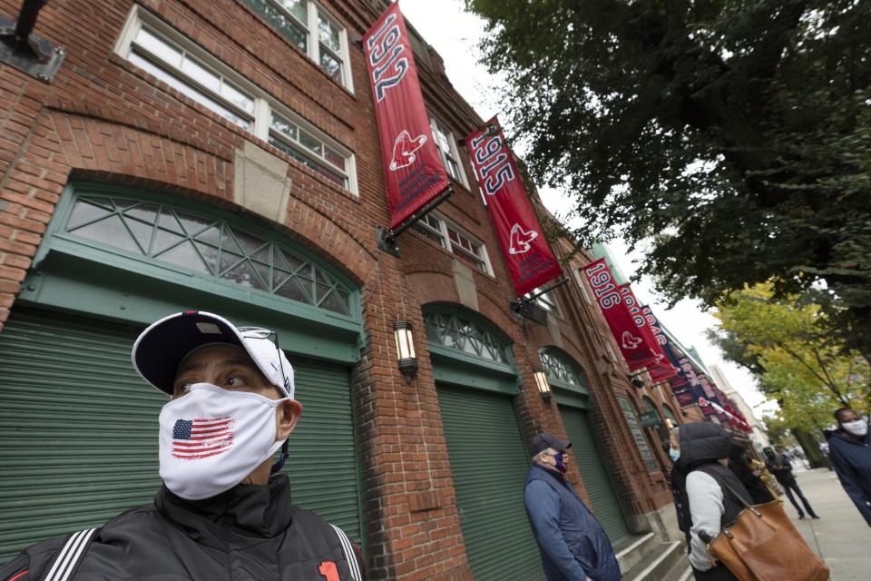 Karen Russell waits in line for early voting to open at Fenway Park, Saturday, Oct. 17, 2020, in Boston. (AP Photo/Michael Dwyer)