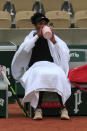 Venus Williams of the U.S. is cover herself with towels to protect against the cold in her first round match of the French Open tennis tournament at the Roland Garros stadium in Paris, France, Sunday, Sept. 27, 2020. (AP Photo/Michel Euler)