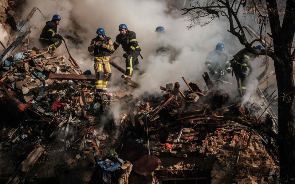 Ukrainian firefighters works on a destroyed building after a drone attack in Kyiv -  YASUYOSHI CHIBA/AFP