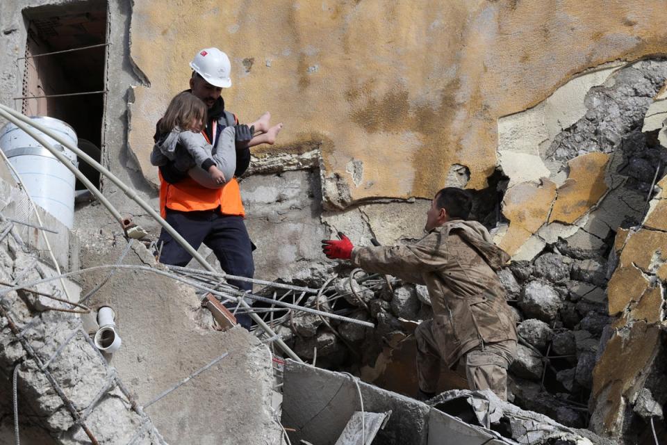 Muhammet Ruzgar, 5, is carried out by rescuers from the site of a damaged building, following an earthquake in Hatay, Turkey, February 7 (REUTERS)