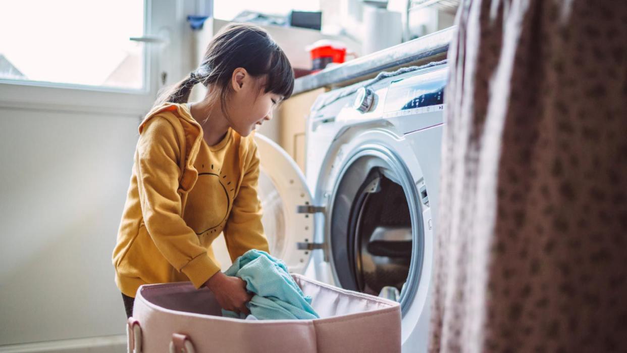 A girl unloading the washing machine